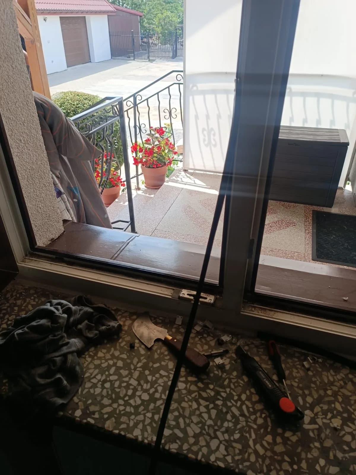 Otwarte skrzydło okienne w kolorze drewna podczas wymiany czarnej uszczelki, obok narzędzia serwisowe.