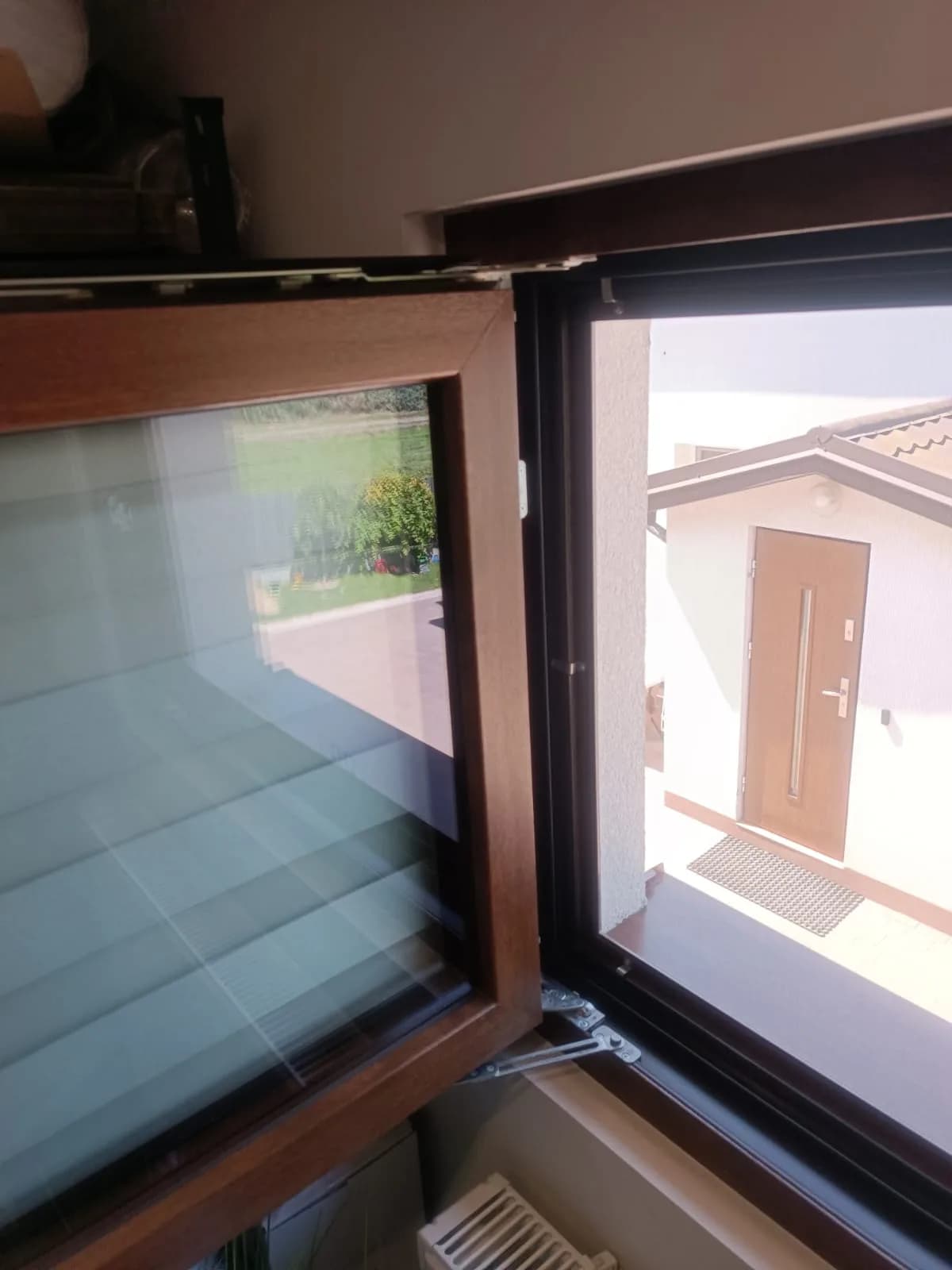Otwarte brązowe okno z widocznym dolnym i górnym okuciem podczas regulacji.