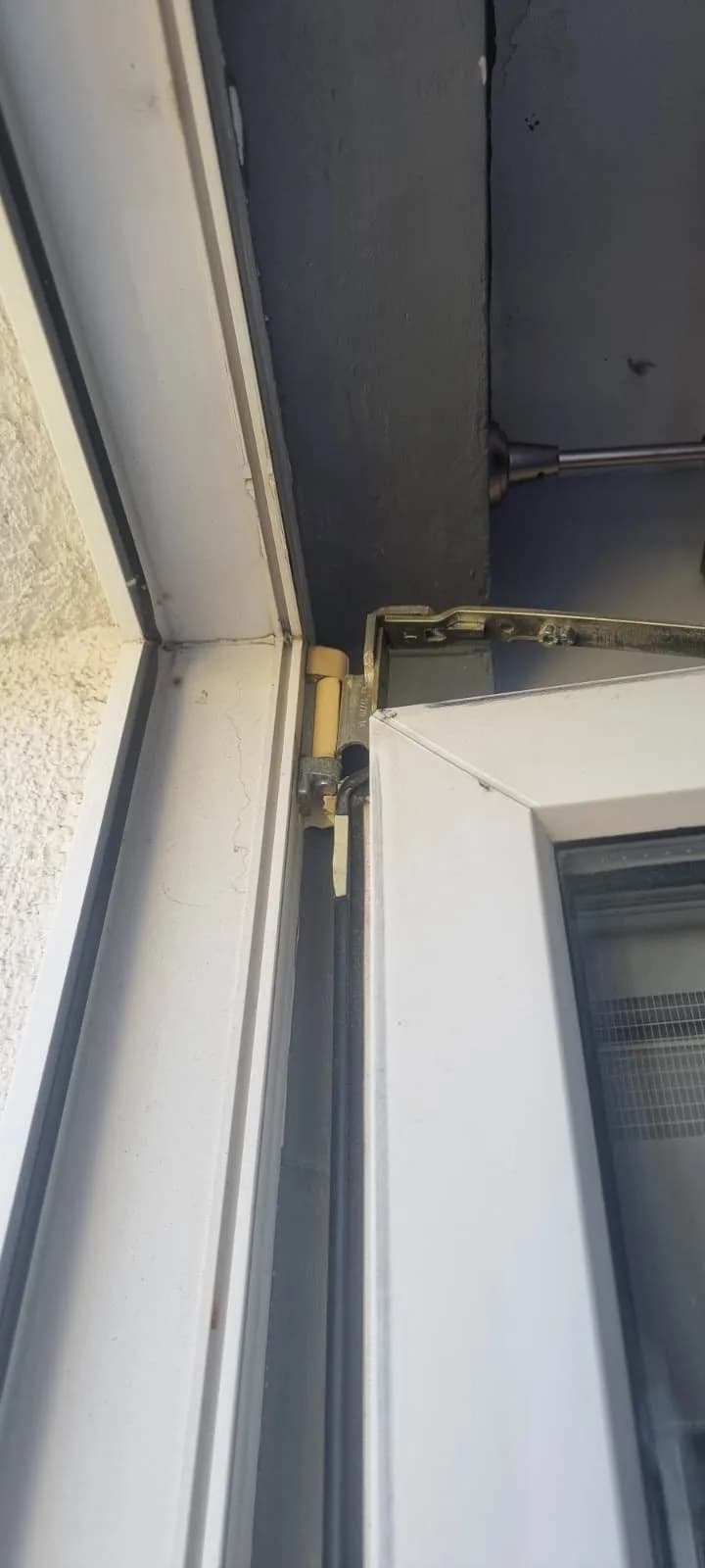 Rozwórka w górnym narożniku białych drzwi balkonowych przed regulacją.